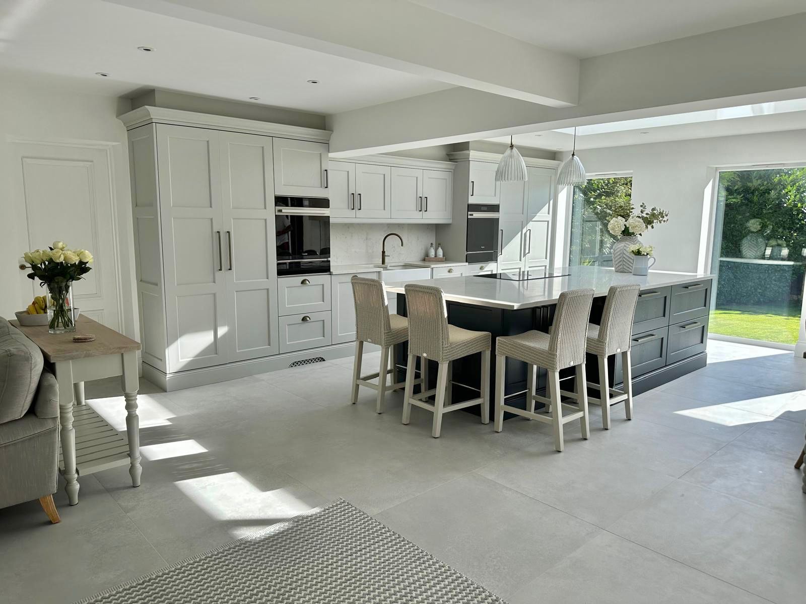 Pale grey fitted open plan kitchen installed by DC Interiors